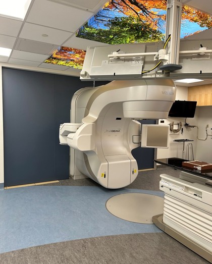 Varian TrueBeam linear accelerator installation with therapeutic ceiling panels in AHS cancer treatment room